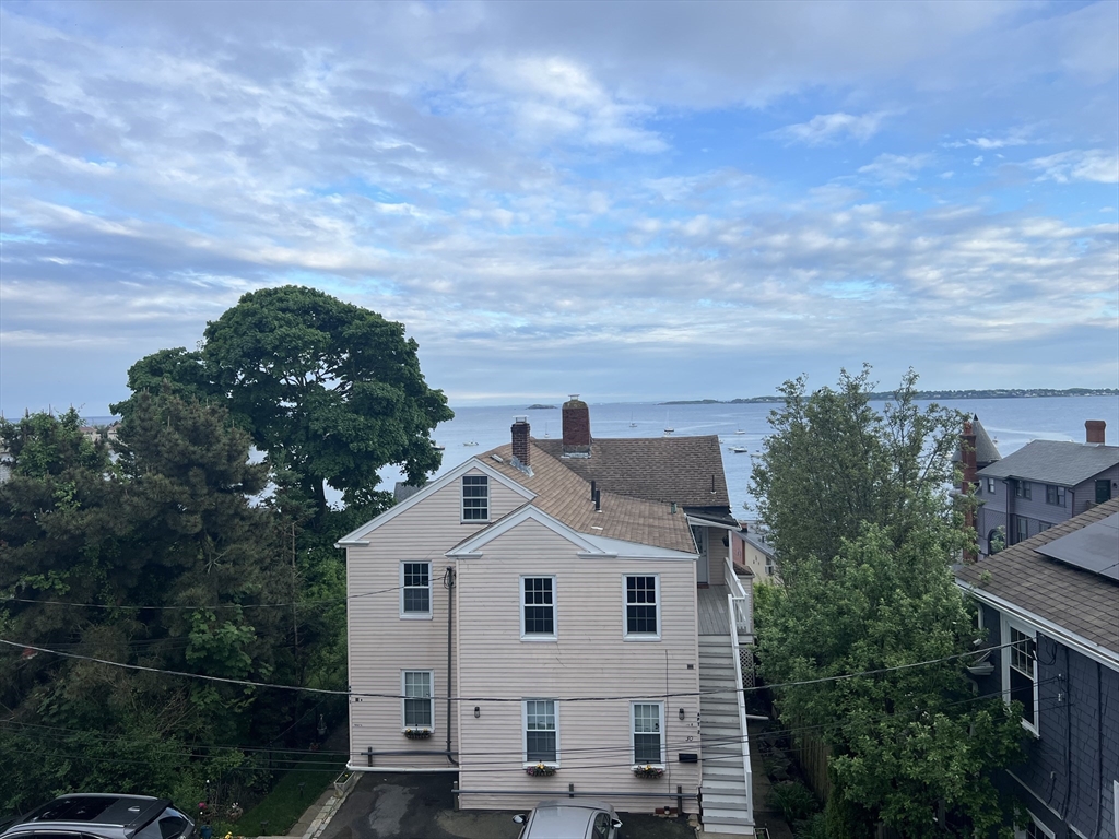 29 Ingalls Terrace, Unit 3 Swampscott, MA 01907 - Photo 12 of 13 a view of a white house next to a yard with plants and large trees