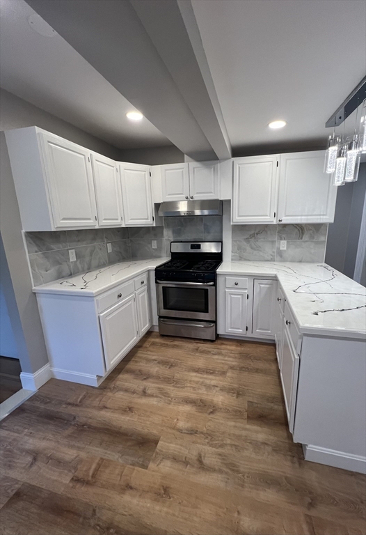 29 Ingalls Terrace, Unit 3 Swampscott, MA 01907 - Photo 5 of 13 a kitchen with wooden cabinets and white stainless steel appliances