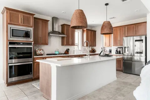 a kitchen with stainless steel appliances granite countertop a sink a stove and a wooden floors