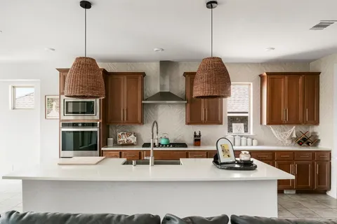 a kitchen with stainless steel appliances granite countertop a sink stove and cabinets