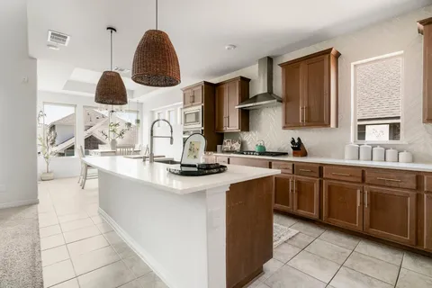 a living room with kitchen island furniture and a chandelier
