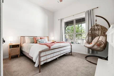 a view of a hallway to a livingroom and a balcony