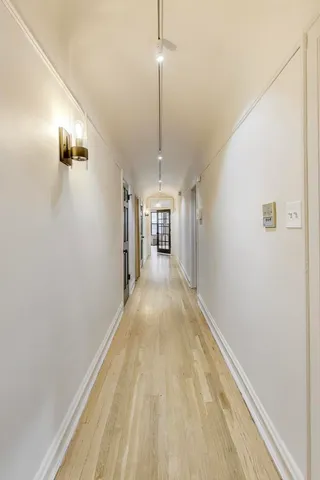 a view of a hallway with wooden floor