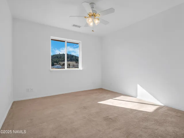 an empty room with a window and a fan