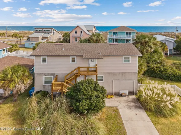 aerial view of a house with a yard and lake view