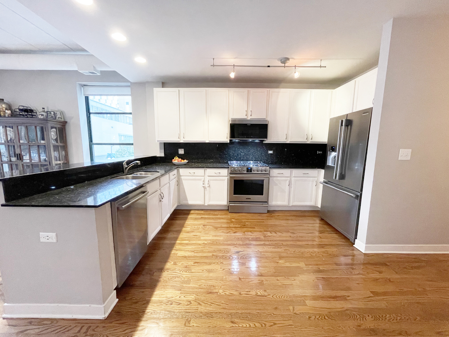 841 West Monroe Street, Unit 3A Chicago, IL 60607 - Photo 3 of 17 a large kitchen with stainless steel appliances granite countertop a stove a sink and a refrigerator