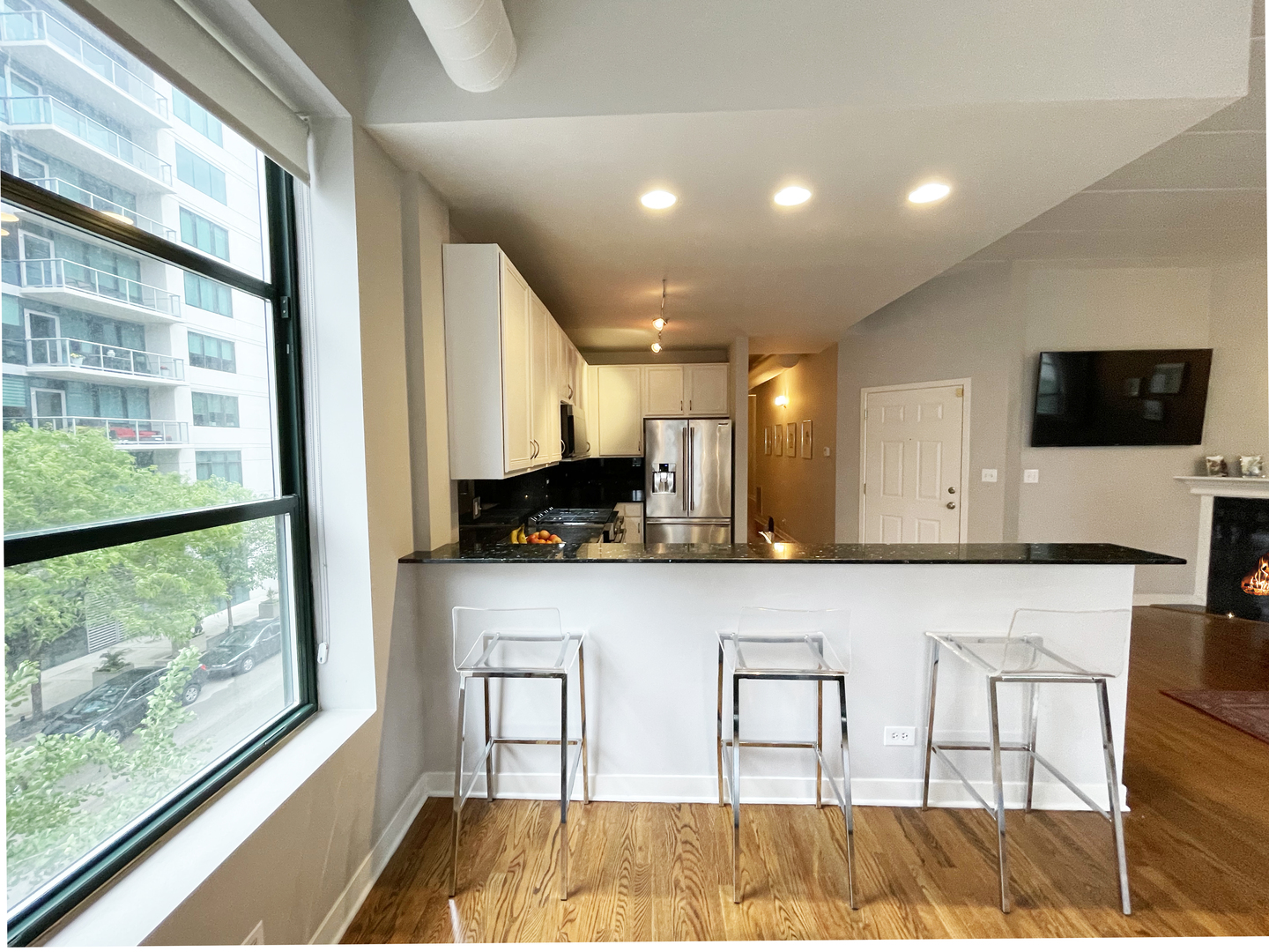 841 West Monroe Street, Unit 3A Chicago, IL 60607 - Photo 7 of 17 a view of kitchen with stainless steel appliances granite countertop a stove and a view of living room