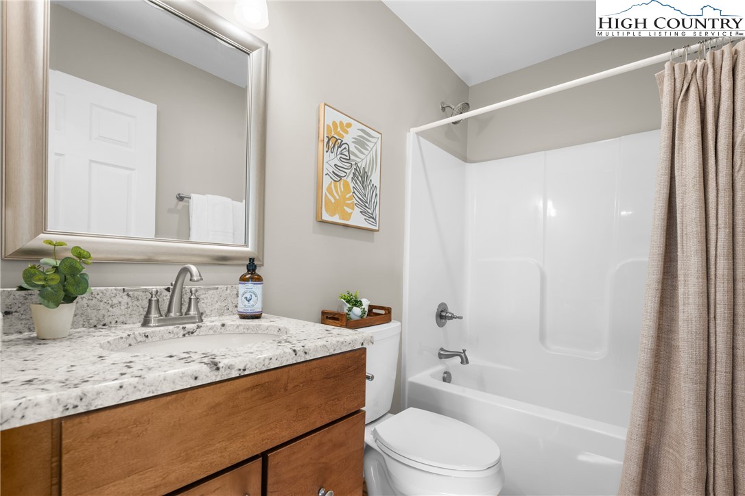 129 Pinebrook Court, Unit 4 Boone, NC 28607 - Photo 18 of 33 a bathroom with a granite countertop sink toilet and shower