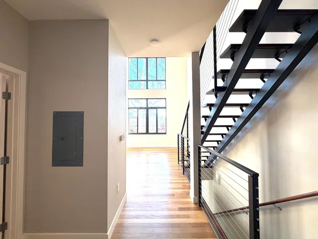 a view of staircase with lots of frames on wall and a window