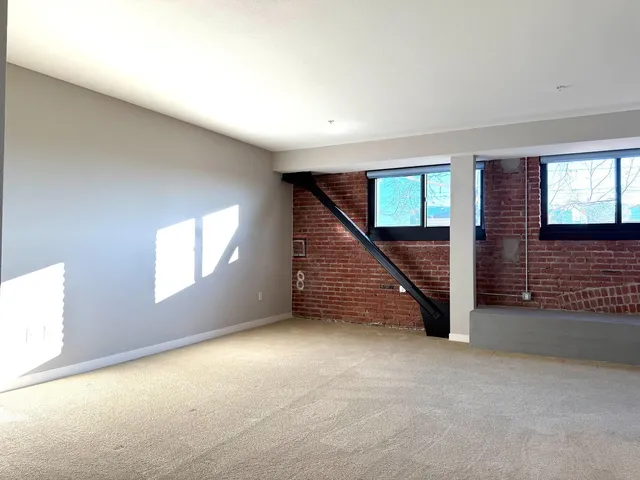 a view of hallway with stairs and wooden floor