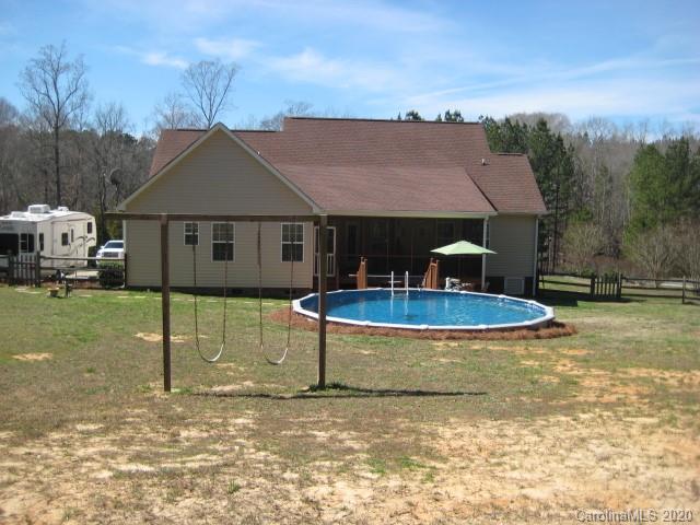 4014 Ruston Creek Road, Unit 86 Catawba, SC 29704 - Photo 44 of 48 a view of a white house next to a yard with a fountain and large trees