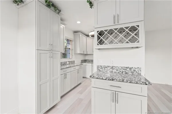 a kitchen with white cabinets and white appliances