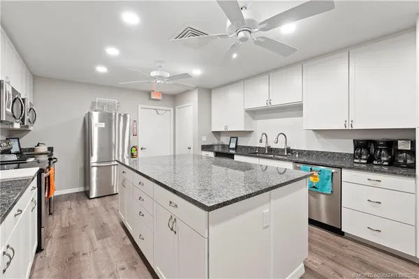 a kitchen with stainless steel appliances granite countertop a sink stove and refrigerator