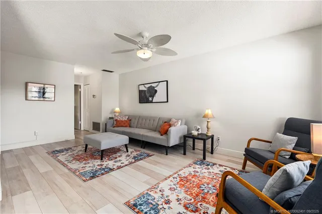 a living room with furniture two windows and a chandelier