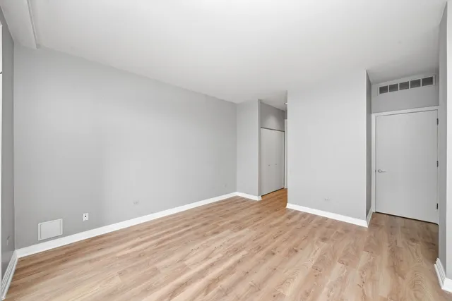 a view of empty room with wooden floor