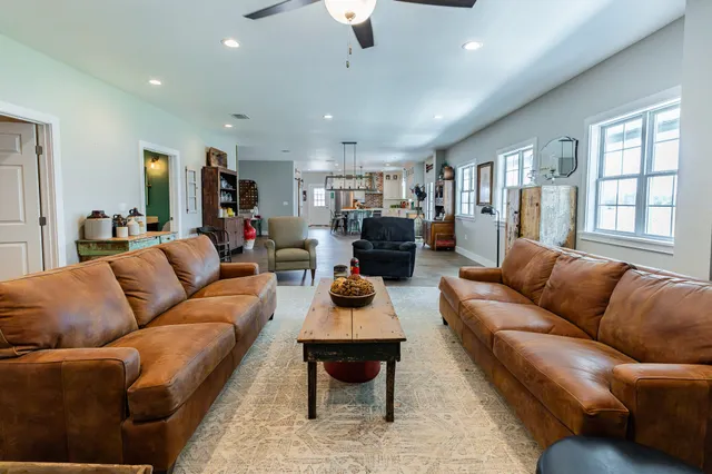 a living room with furniture ceiling fan and a window