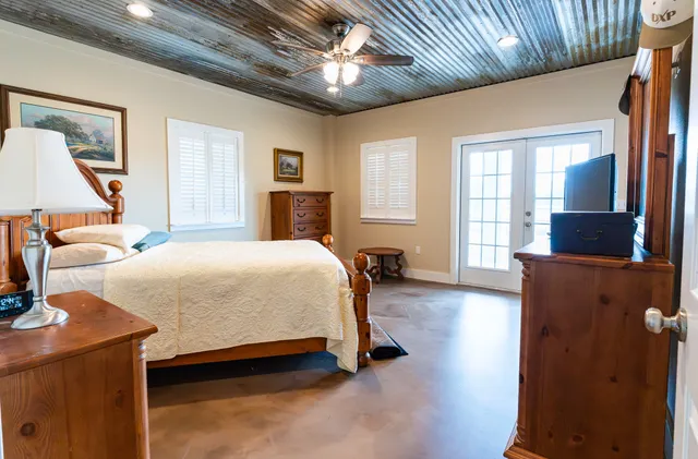 a spacious bedroom with a bed and wooden floor