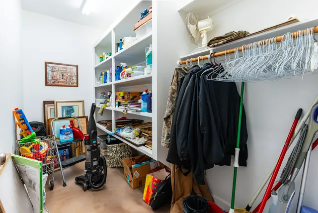 a view of walk in closet with clothes and shoes