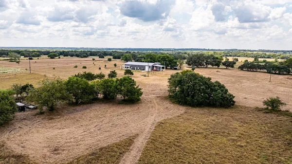a front view of house with yard and trees around