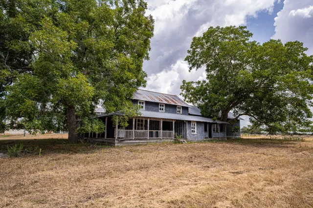 a front view of house with yard and trees around