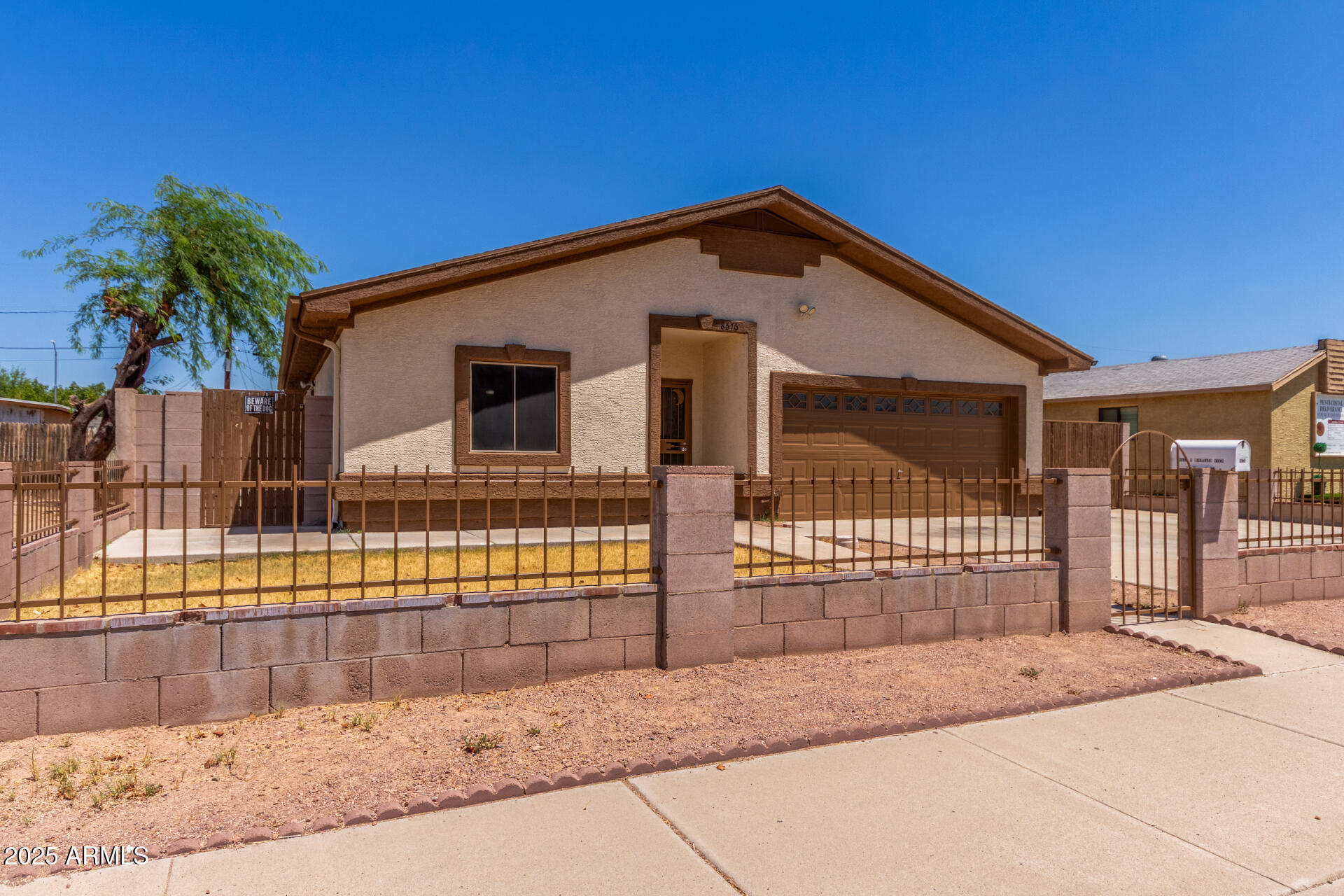 8676 West Mountain View Road Peoria, AZ 85345 - Photo 5 of 33 a view of a house with wooden fence and large trees