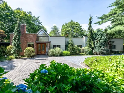 a front view of a house with a yard and potted plants