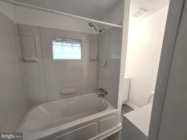 a white bath tub sitting next to a shower