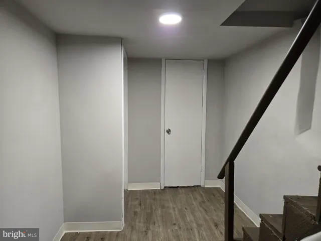 a view of hallway with stairs and wooden floor