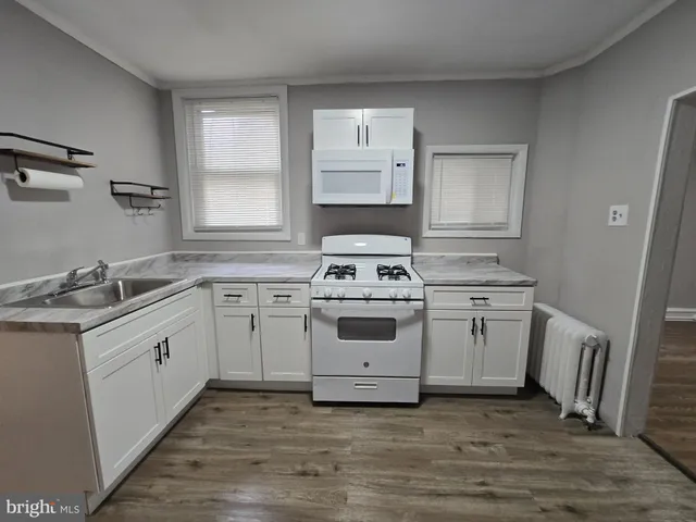a white kitchen with sink and window