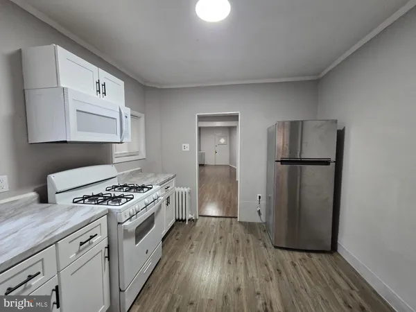 a kitchen with stainless steel appliances granite countertop a stove a refrigerator and a cabinets