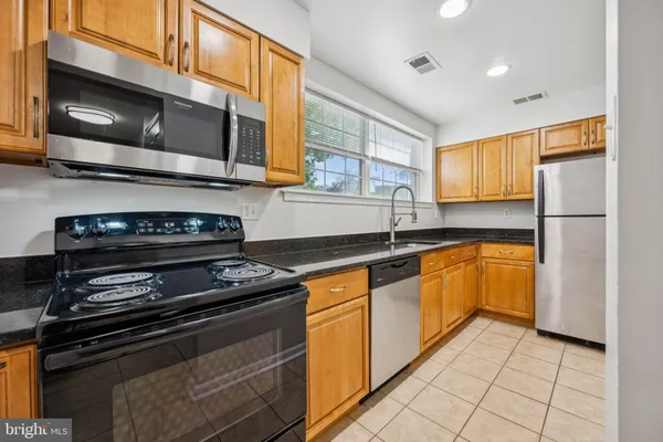 a kitchen with stainless steel appliances a stove a microwave and a sink