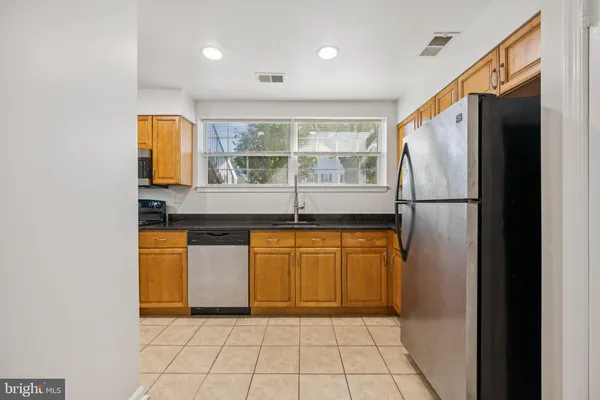 a kitchen with stainless steel appliances granite countertop a refrigerator and a sink