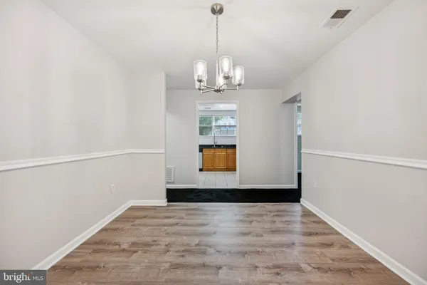 a view of a big room with wooden floor and windows