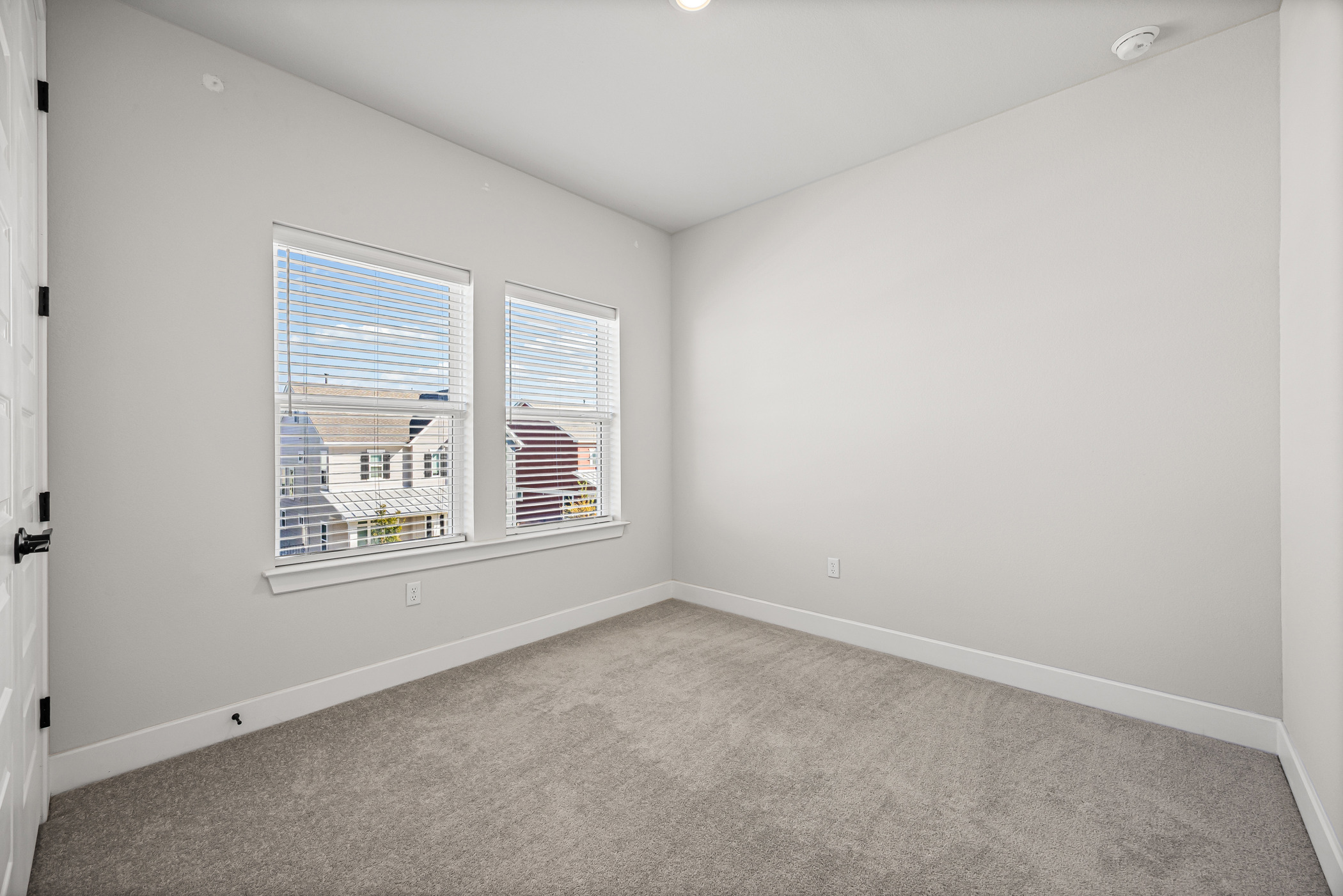 5806 Rangeland Road Austin, TX 78747 - Photo 22 of 34 A well-lit, neutral-toned room features broad windows, offering a versatile space for any design.