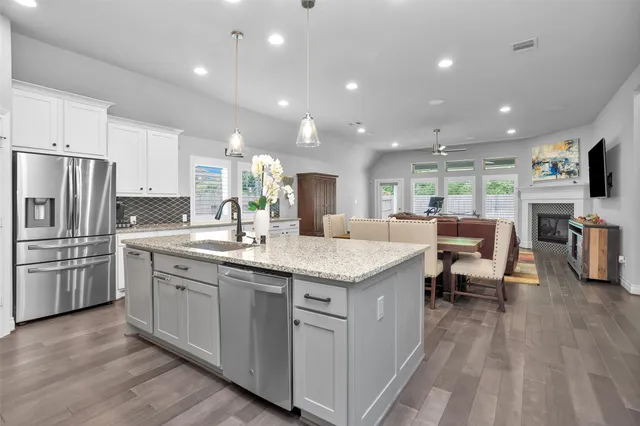 a kitchen with stainless steel appliances granite countertop a sink stove and refrigerator