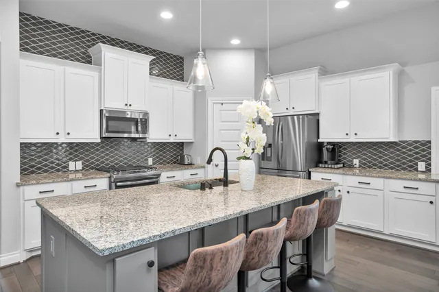a kitchen with kitchen island a white counter space a sink cabinets and appliances