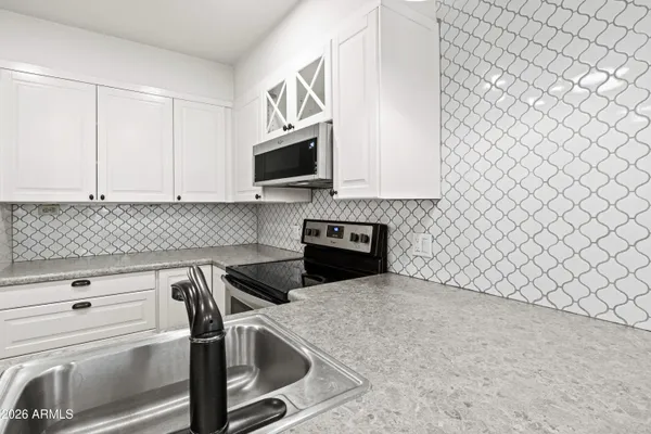 a kitchen with a sink and a stove top oven