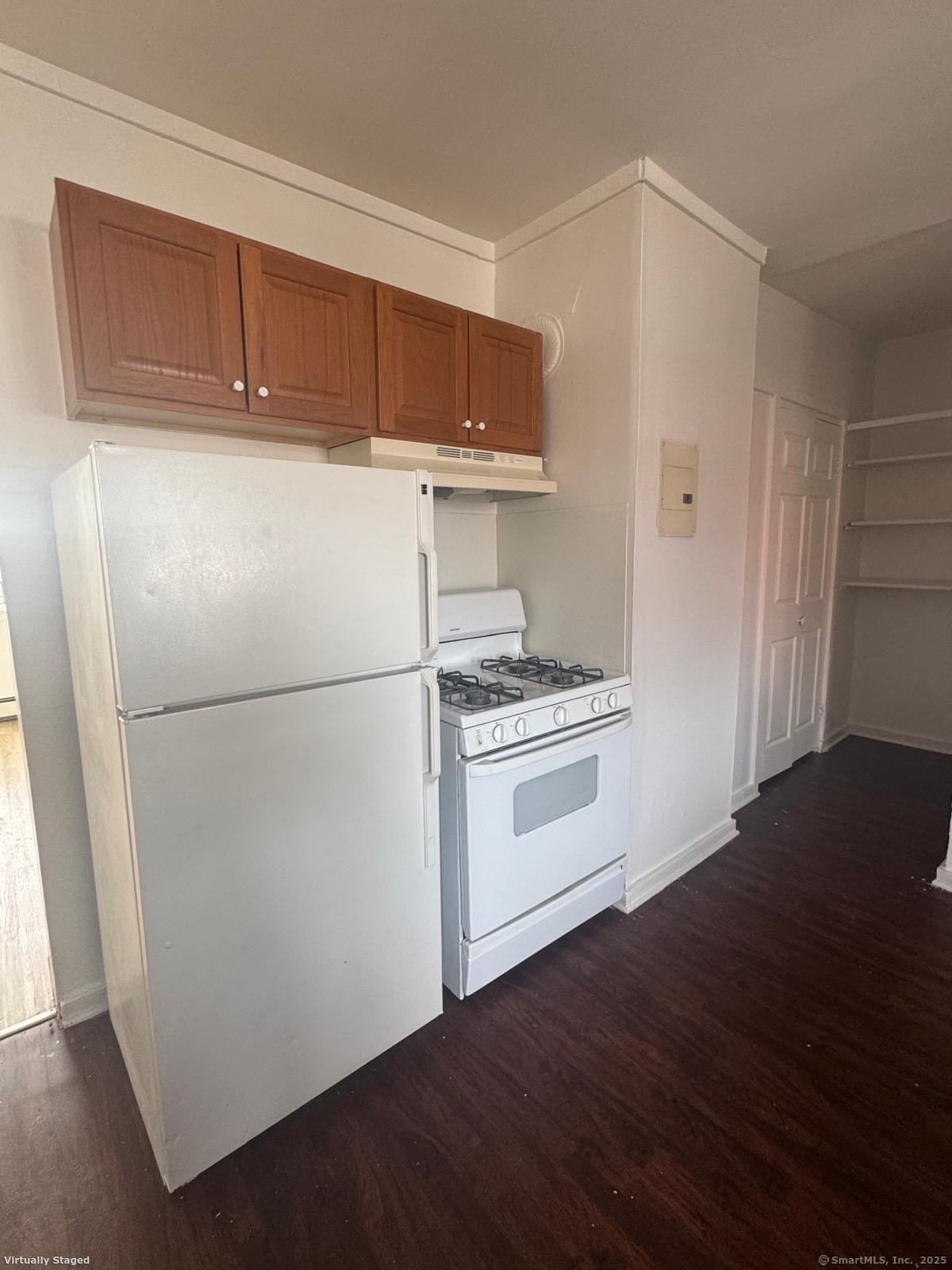 a kitchen with a refrigerator and a stove top oven