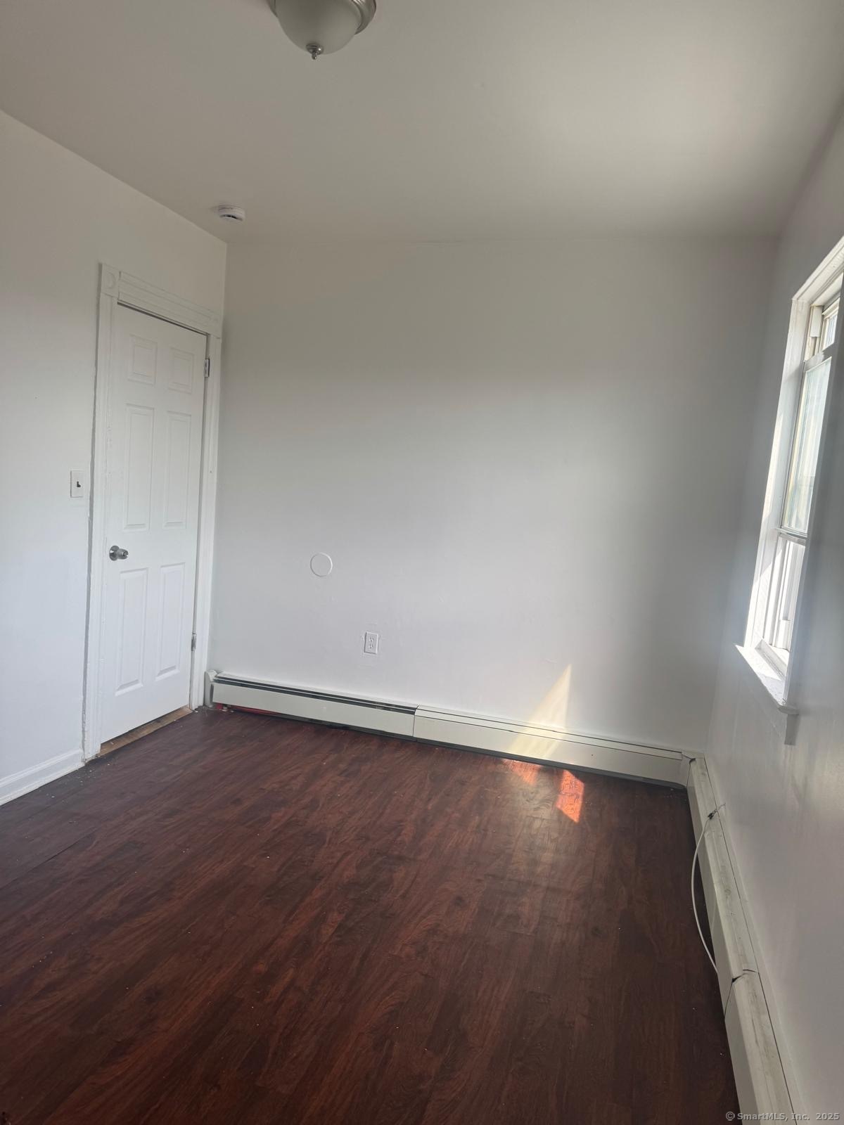 202 Noble Avenue, Unit 3 Bridgeport, CT 06608 - Photo 2 of 6 an empty room with wooden floor and windows