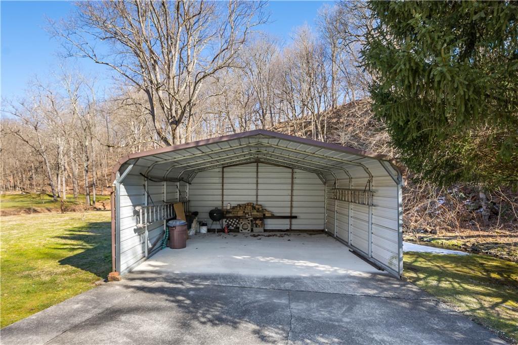 69 Pike Run Road Daisytown, PA 15427 - Photo 13 of 39 a blue bench sitting under a large tree next to a road