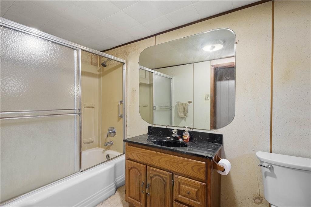 69 Pike Run Road Daisytown, PA 15427 - Photo 25 of 39 a bathroom with a granite countertop sink a mirror and a bathtub
