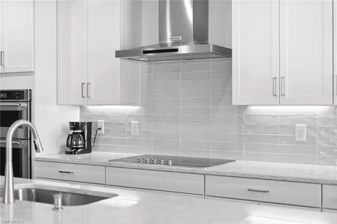 a kitchen with stainless steel appliances kitchen island granite countertop a stove a table and chairs in it