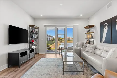 a living room with furniture and a floor to ceiling window