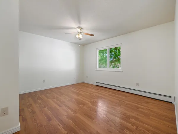 a view of empty room with wooden floor