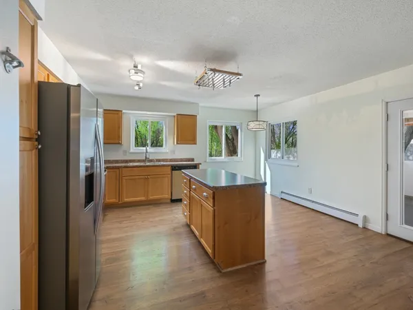a large kitchen with stainless steel appliances granite countertop a sink and a refrigerator