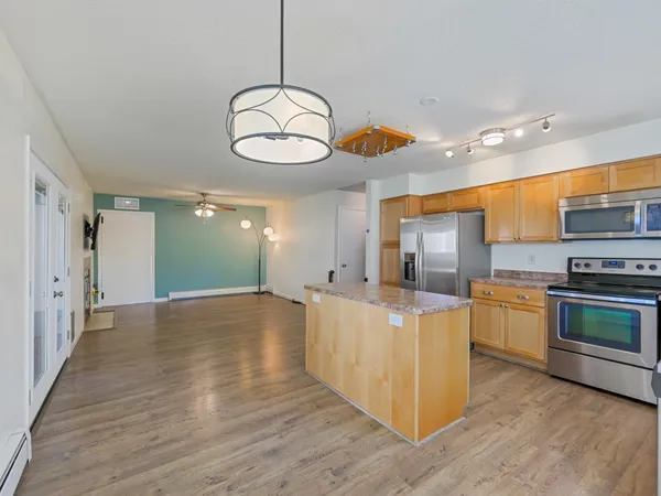 a kitchen with stainless steel appliances granite countertop a stove top oven a refrigerator and a sink