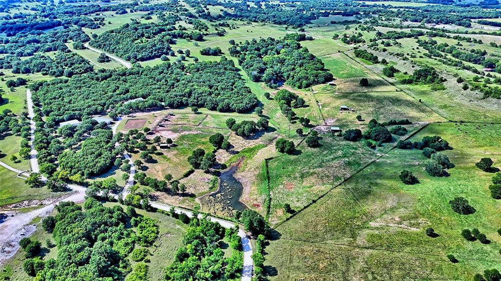 4509 Lazy E Road St. Jo, TX 76265 - Photo 39 of 39 an aerial view of a house with a lush green forest