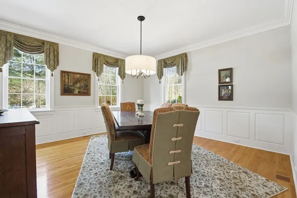 a dining room with furniture a chandelier and wooden floor