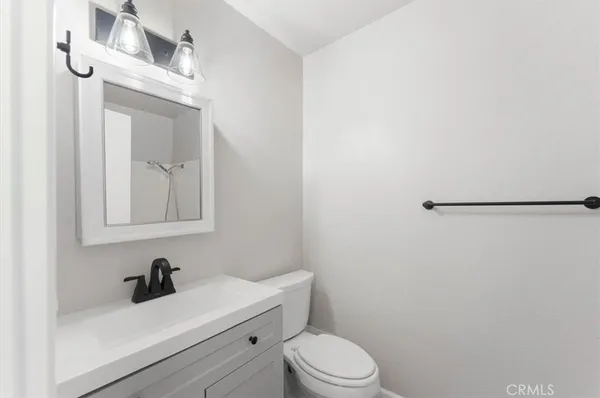 a bathroom with a toilet a sink a mirror and vanity