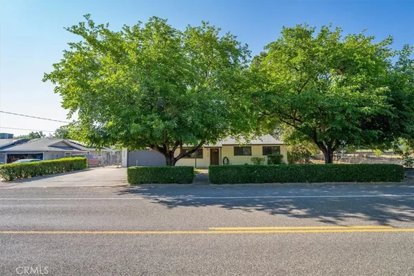 a front view of a house with a yard and trees